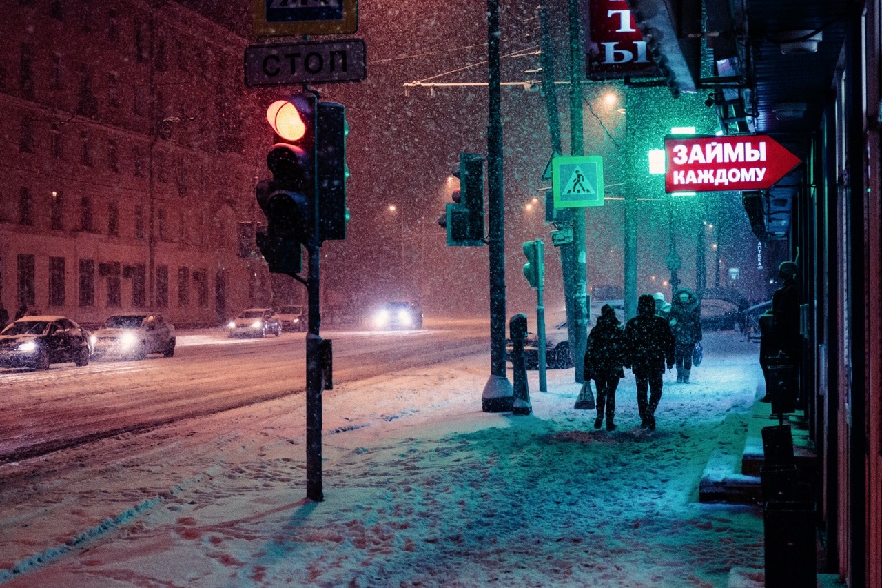 A snowy night in Moscow with people walking in the street